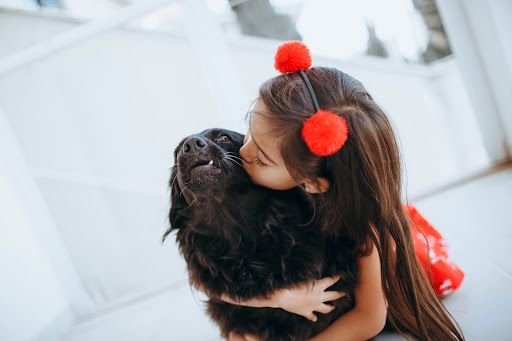 Child giving dog a hug